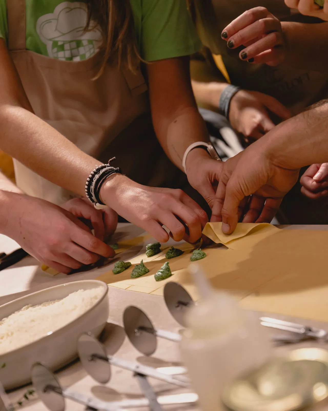 Plusieurs paires de mains au travail autour d'une table d'atelier