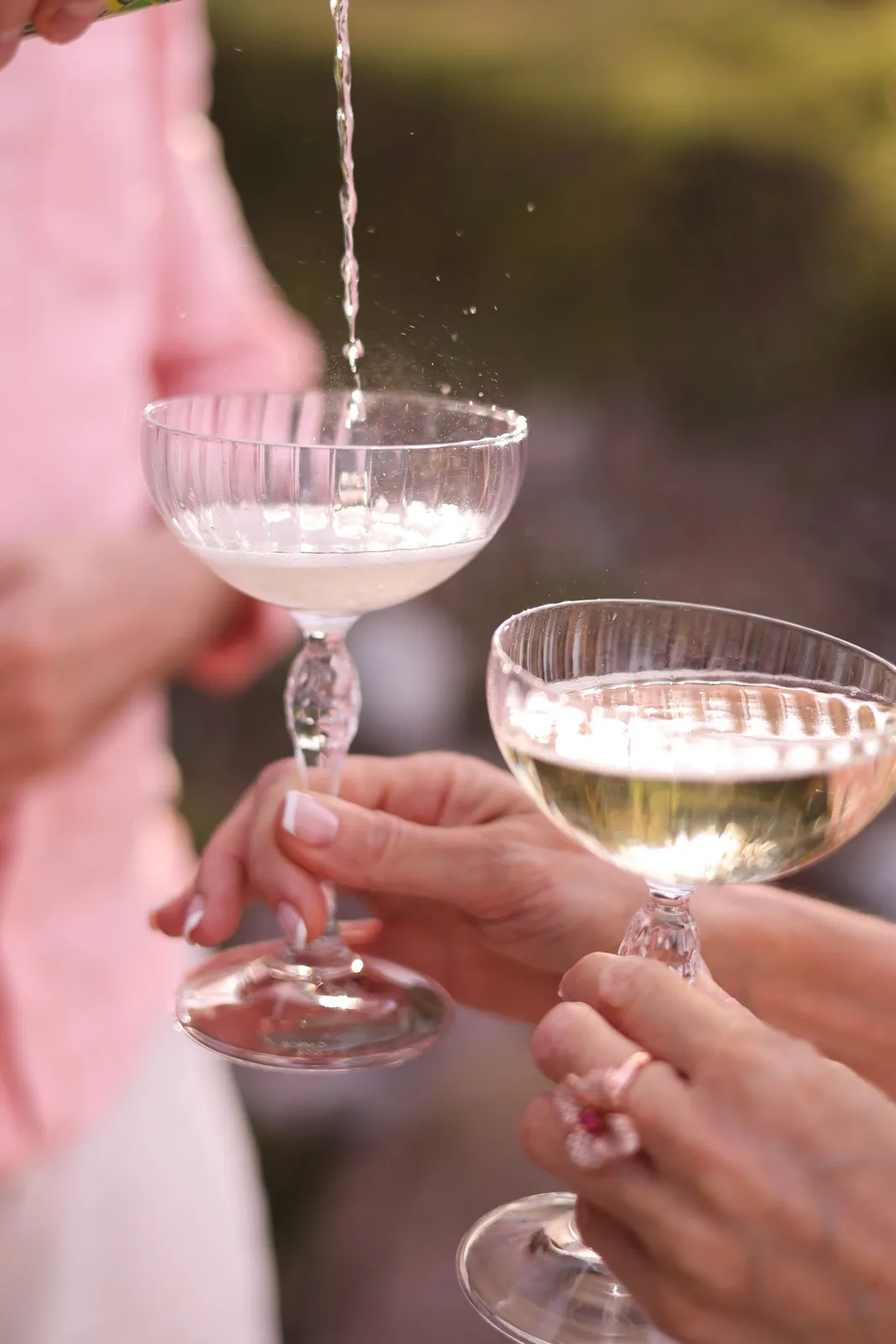 Deux mains trinquant avec des coupes de champagne
