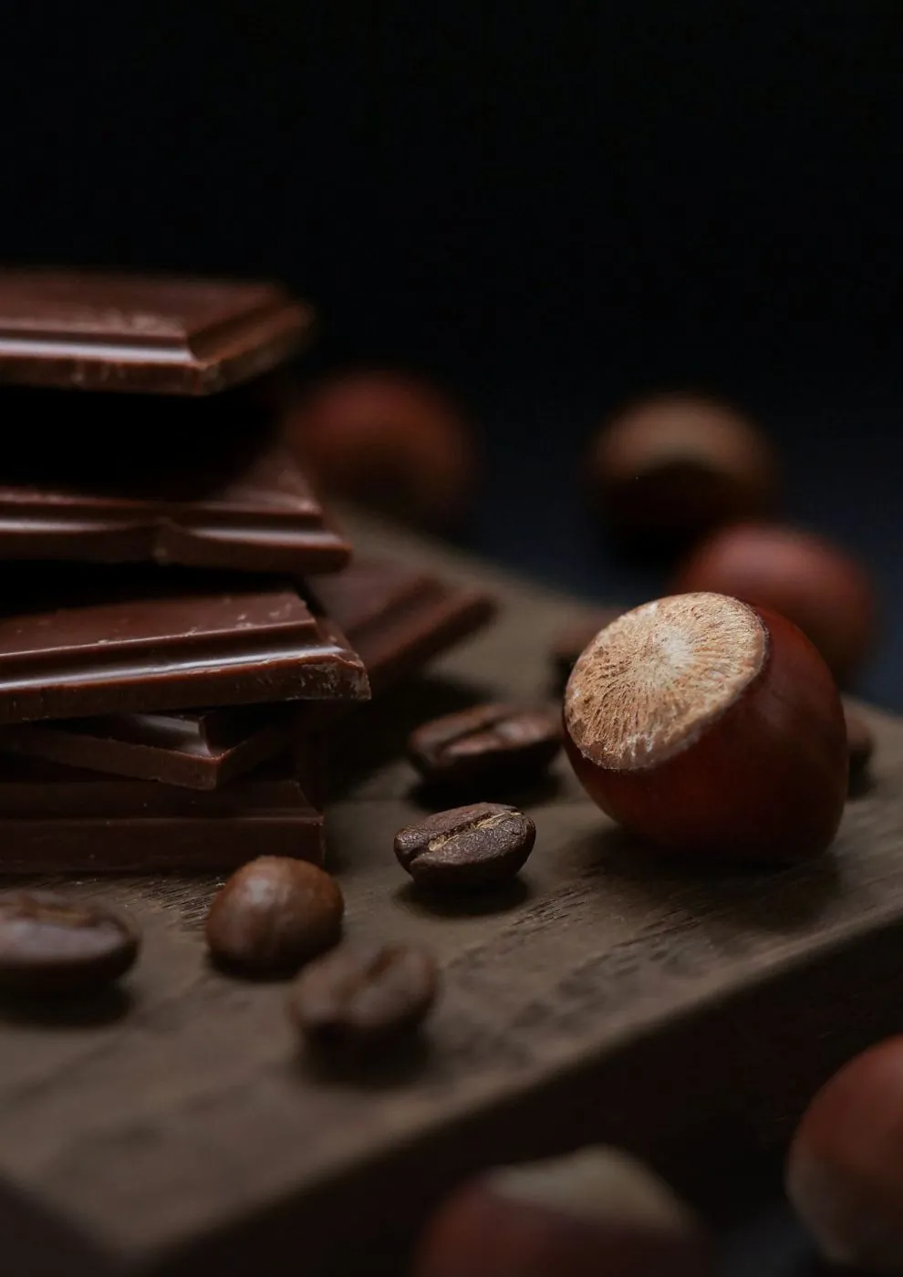 Chocolat et noisettes sur une planche en bois