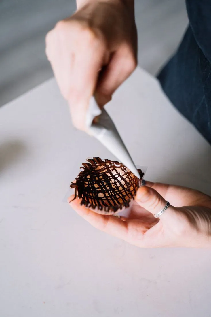 Une main coupe un bonbon de chocolat