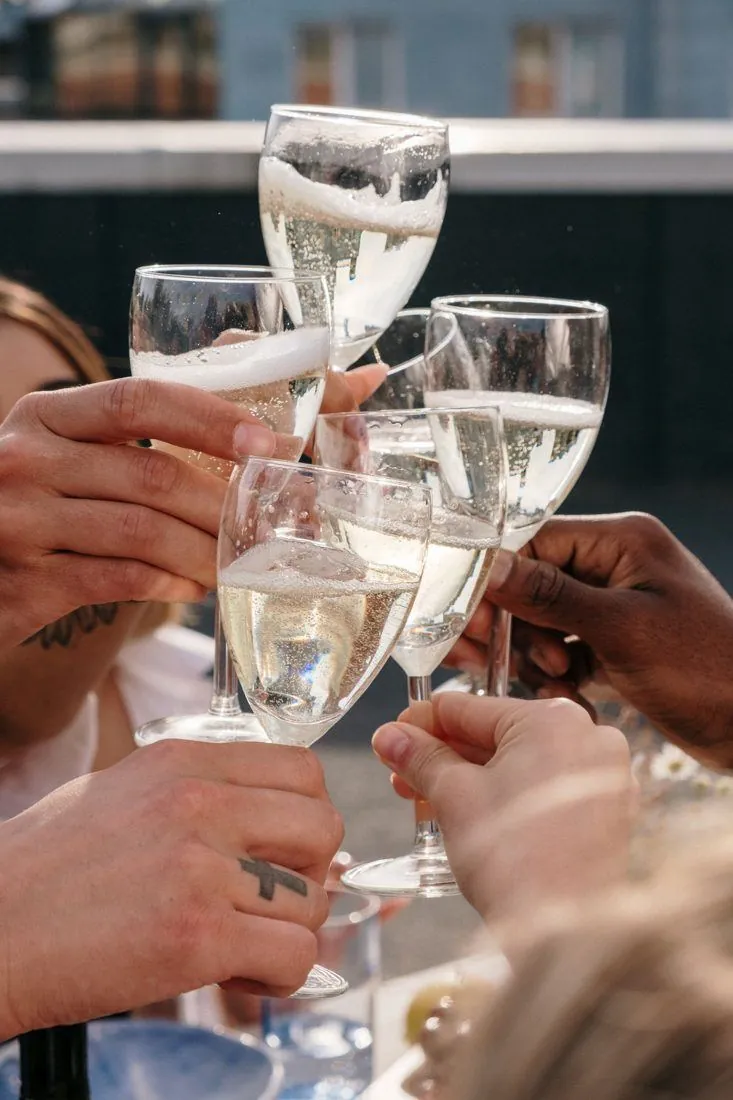 Des mains lèvent des coupes de champagne