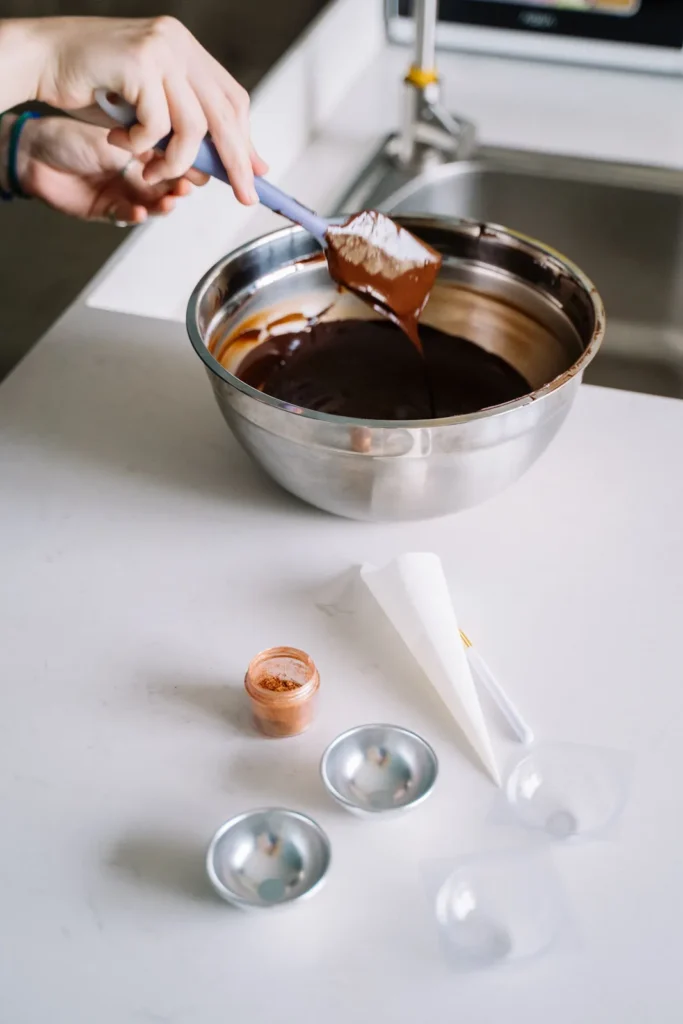 Chocolat fondu mélangé à la spatule dans un bol en inox